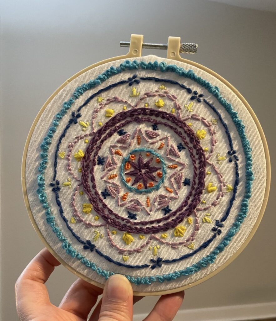 Embroidery disk with stitched multicolor circular motif