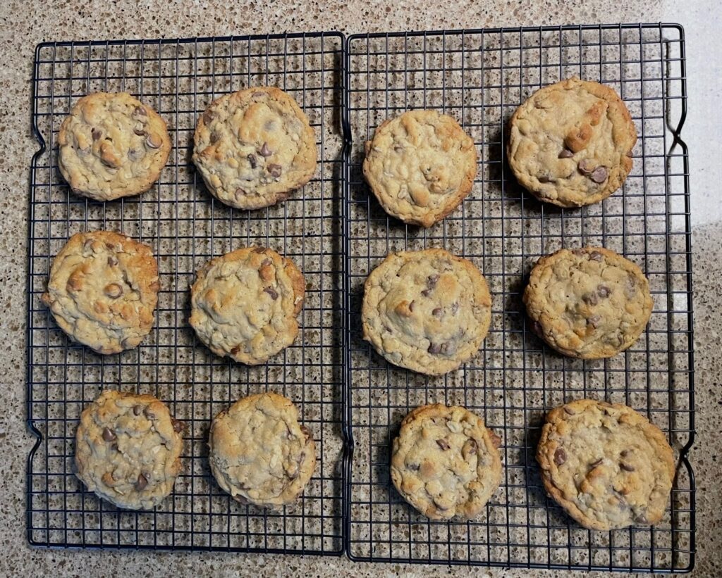 Homemade chocolate chip oatmeal cookies cooling on metal racks