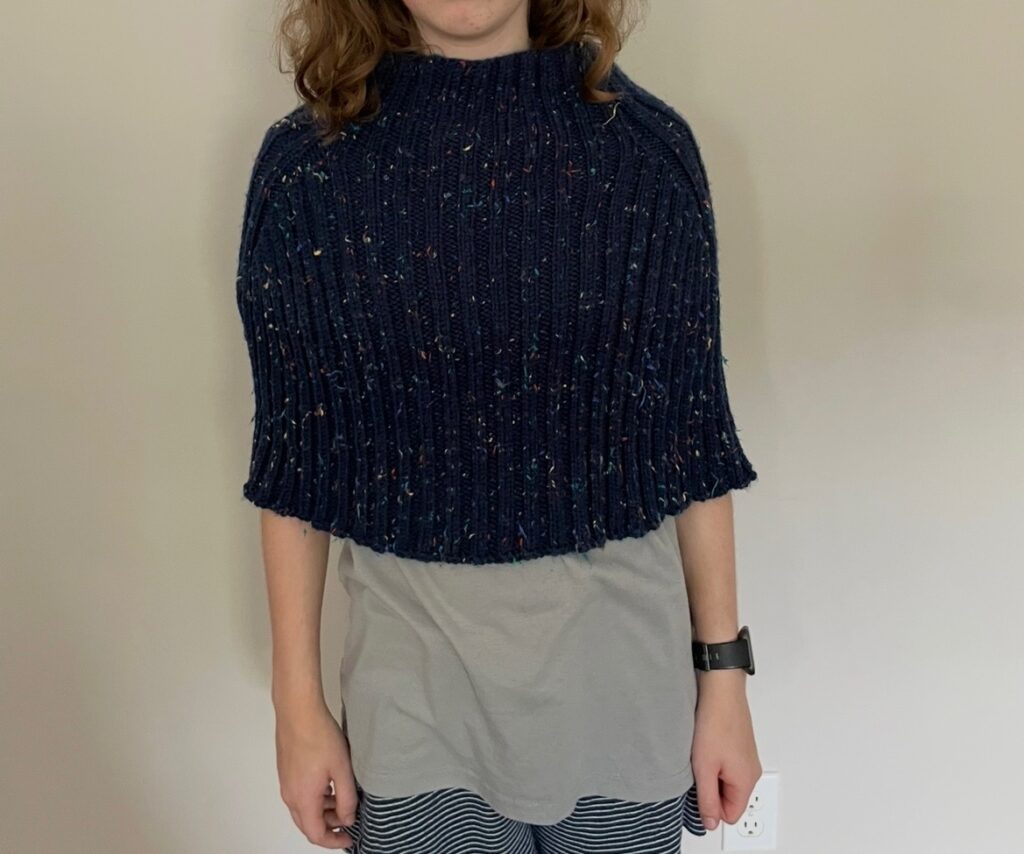 Navy blue knit poncho on a teenager