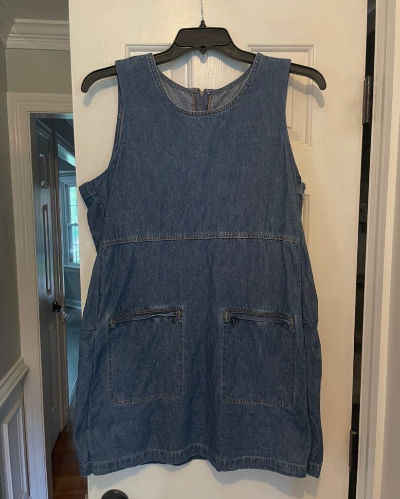 Jean tank style dress on a hanger, hanging on a door 