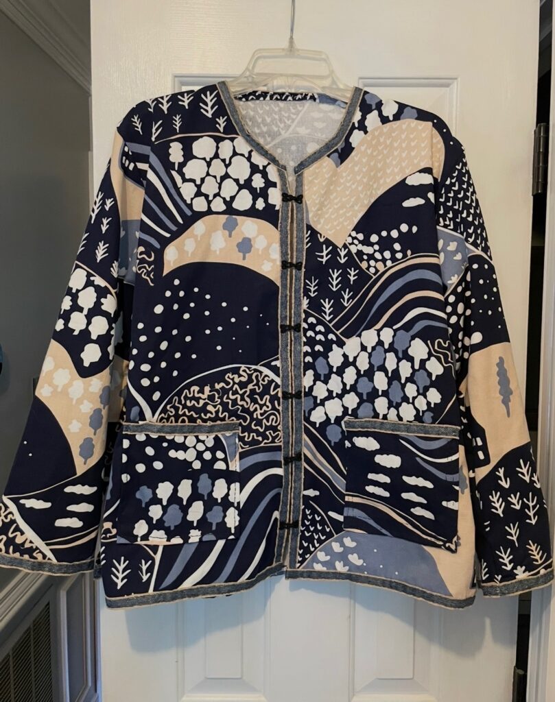 Multicolor jacket on a hanger, hanging on a door.